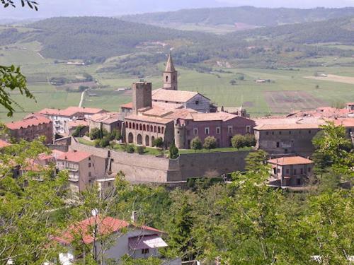 un pequeño pueblo con una iglesia y una colina en Casa della zia rosa, en Valentano