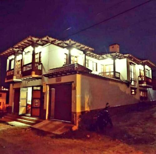 a large white house with lights on it at night at Hospederia Sandaned in Villa de Leyva