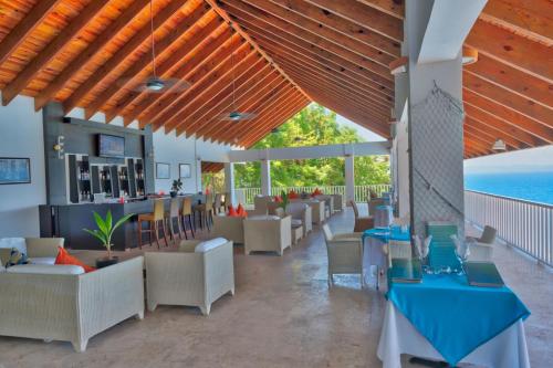 a restaurant with tables and chairs and a bar at Vista Mare Samana Amazing Views!! in Santa Bárbara de Samaná