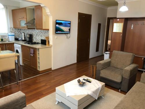 a living room with a table and a kitchen at Stella Classic Apartments in Fethiye