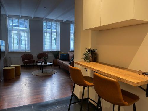 een woonkamer met een bank en een tafel en stoelen bij Vakantie appartement Sunndays in Valkenburg