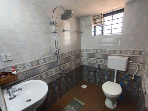 a bathroom with a toilet and a sink and a shower at UDUPI HOMESTAY - Hill Top Villa in Udupi