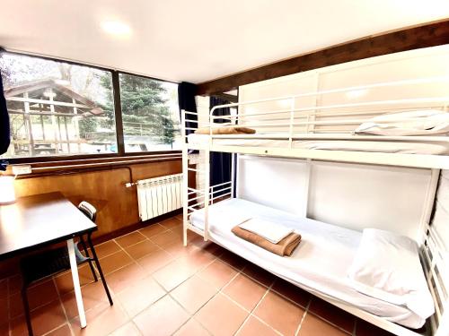 a dorm room with bunk beds and a desk at Hostel albergue Paradiso in Hinojedo