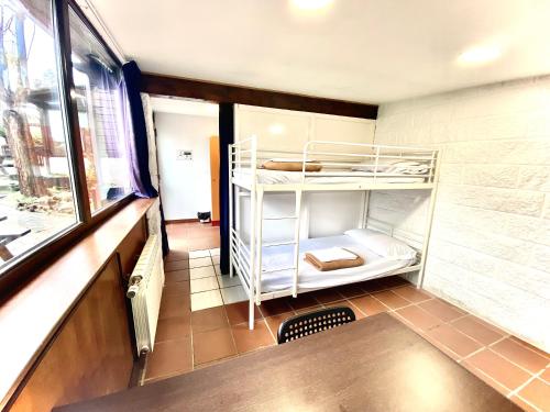 a small room with bunk beds in it with a window at Hostel albergue Paradiso in Hinojedo