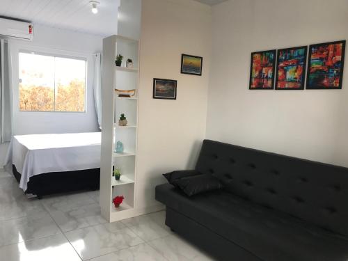 a living room with a couch and a bed at Residencial Campeche 1 in Florianópolis