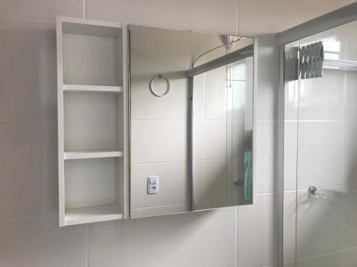 a bathroom with a shower and a glass door at Residencial Campeche 1 in Florianópolis