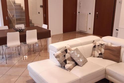 a living room with a white couch and a table at B&B accogliente a due passi dal metrò di Milano - Casa Adriana in Cologno Monzese