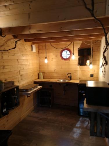 - une cuisine avec des murs en bois, un évier et une fenêtre dans l'établissement Sortilège, à Lambesc