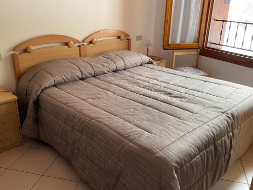 1 dormitorio con 1 cama grande y cabecero de madera en Hotel Le Polle en Riolunato