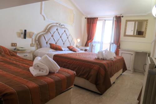 a hotel room with two beds with towels on them at Hotel Tahiti in Viareggio
