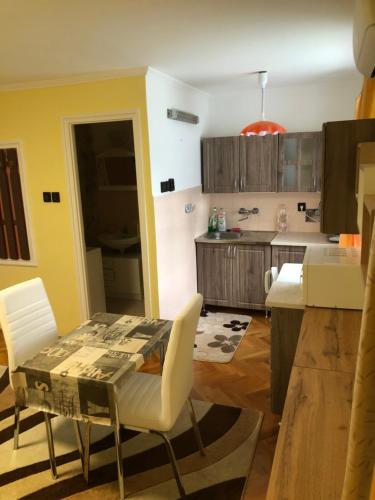 - une cuisine avec une table et des chaises dans la chambre dans l'établissement BB apartman, à Harkány