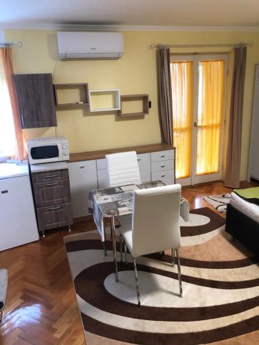 Il comprend une cuisine et un salon avec une table et des chaises. dans l'établissement BB apartman, à Harkány