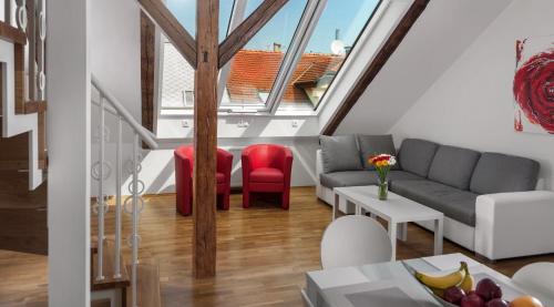 a living room with a couch and red chairs at Residence Vocelova in Prague