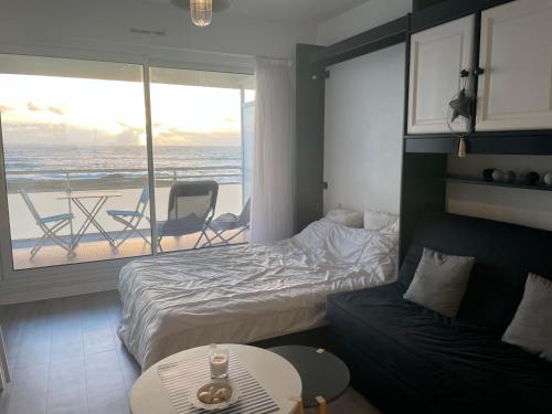 een slaapkamer met 2 bedden en een balkon met uitzicht op de oceaan bij Vue mer imprenable - Grande plage à pied - Parking in Quiberon