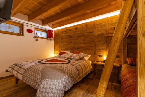 um quarto com uma cama num quarto com paredes de madeira em Nido del Brenta em Madonna di Campiglio