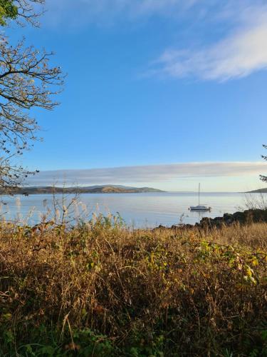 a view of the ocean with a boat in the water at Balcary Bay Country House Hotel in Auchencairn