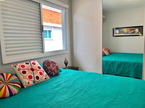 1 dormitorio con 2 camas y ventana en Lindo apartamento, com excelente localização, em Jurerê!, en Florianópolis