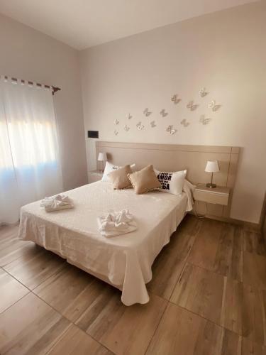 Un dormitorio con una cama blanca con pájaros en la pared en La Pedrera Apart, en Villa María