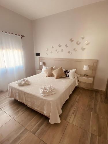 a bedroom with a white bed with birds on the wall at La Pedrera Apart in Villa María