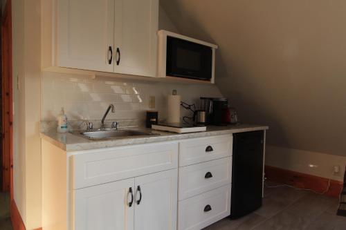a kitchen with a sink and a microwave at Harbourview Inn in Smiths Cove