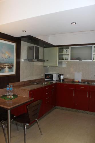 a kitchen with red cabinets and a table with chairs at Herrmes Hospitality in Sharm El Sheikh