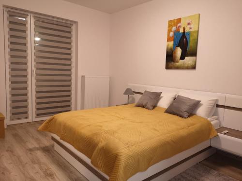 um quarto com uma cama amarela com um quadro na parede em Apartament Marzenie 2 - Opole em Opole