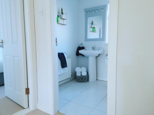 a white bathroom with a sink and a mirror at Castlebar 3 bedroom house in Castlebar