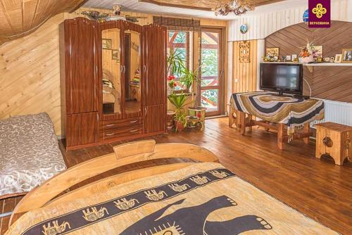 a living room with a bed and a television at Kitica house in Verkhovyna