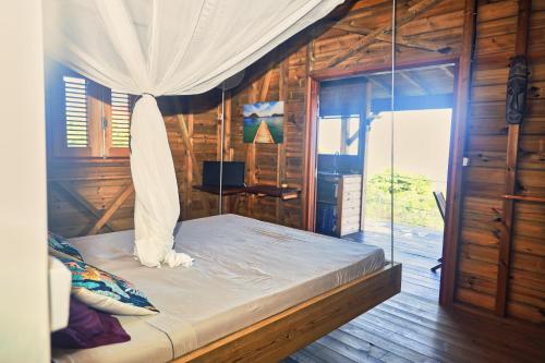 Katil atau katil-katil dalam bilik di TI KAZ ANOLI Cottage en bois avec vue sur la baie