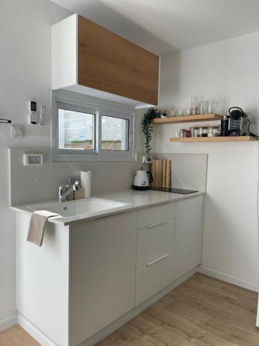 a white kitchen with a sink and a window at Emanuel Suite in Eilat