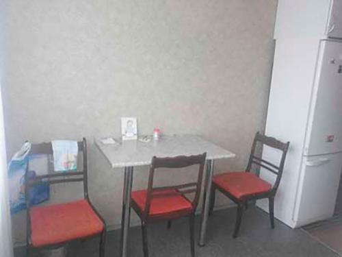 Окрема кімната без підселення в трикімнатній квартирі біля метро Оболонь في كييف: طاولة بأربعة كراسي وطاولة مع ثلاجة