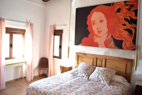 a bedroom with a bed with a large painting on the wall at Castillo de Bulbuente de Luis Zueco in Bulbuente