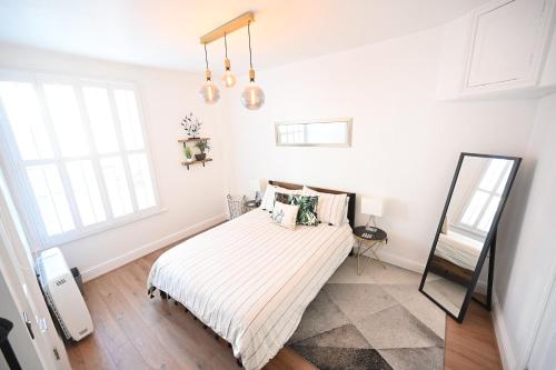 a white bedroom with a bed and a mirror at The Teapot Cottage in Town Centre FREE Parking in Stratford-upon-Avon