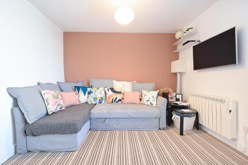a living room with a couch and a flat screen tv at The Teapot Cottage in Town Centre FREE Parking in Stratford-upon-Avon