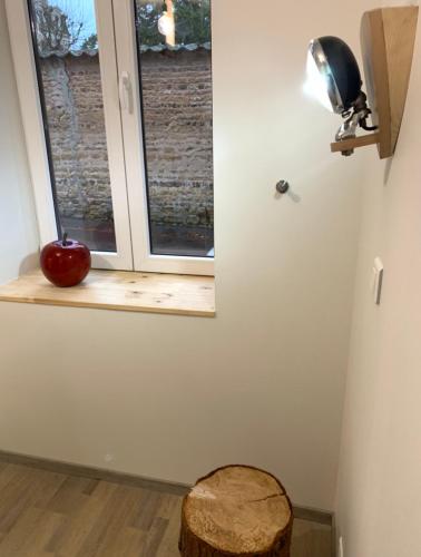 an apple sitting on a window sill in front of a window at Gîte le BISTANCLAC. in Charlieu