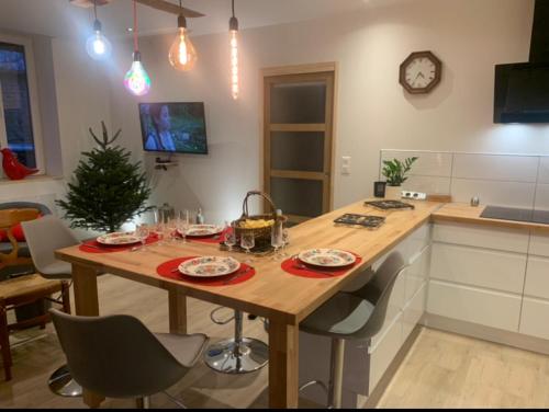 a kitchen with a wooden table with dishes on it at Gîte le BISTANCLAC. in Charlieu