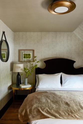 a bedroom with a large bed and a table with a lamp at The Cornell Inn, Lenox & The Berkshires in Lenox