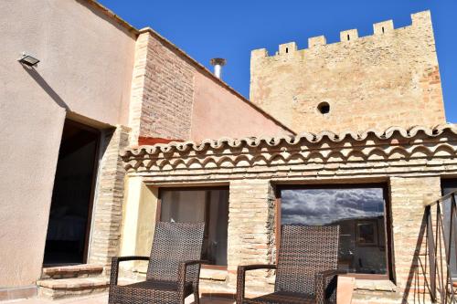 two chairs are sitting outside of a building at Castillo de Bulbuente de Luis Zueco in Bulbuente