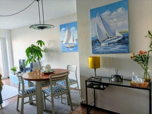 a dining room with a table and sailboats on the wall at Vista Azul in Baiona