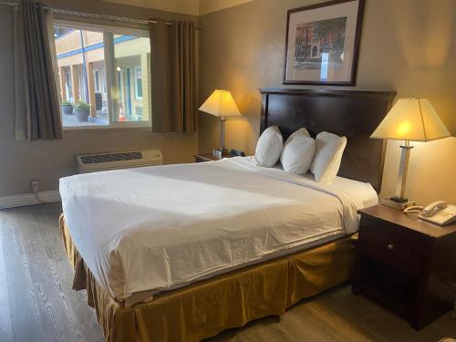 a hotel room with a large bed with two lamps at Travelodge by Wyndham Everett City Center in Everett