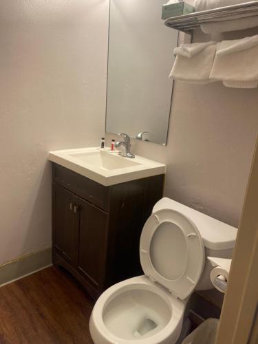 a bathroom with a sink and a toilet and a mirror at Travelodge by Wyndham Everett City Center in Everett