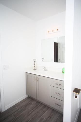 a white bathroom with a sink and a mirror at A beautiful queen bedroom in Orlando