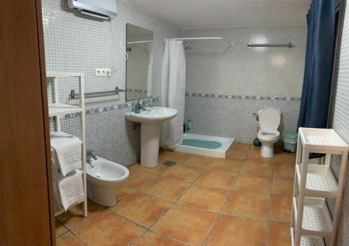 a bathroom with a sink and a toilet and a tub at Cortijo Mazarrón in Güéjar-Sierra