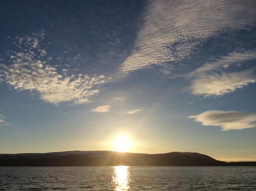 a sun setting over a body of water at Hotel Repvåg in Repvåg