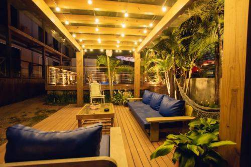 a patio with blue couches and plants on a building at Pousada Cacau in Praia do Rosa