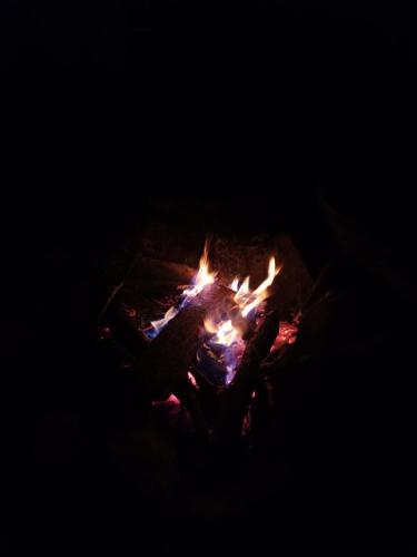 a person sitting around a campfire in the dark at Casa de campo Jaulares in Alaska