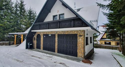 a house with a black and white roof at Willa Jaszczurówka in Zakopane