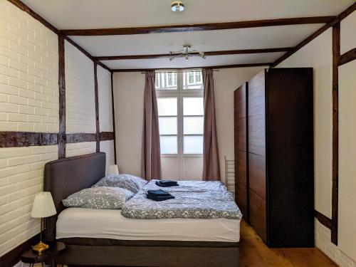 a bedroom with a bed and a window at LüneMitte - An der Münze in Lüneburg