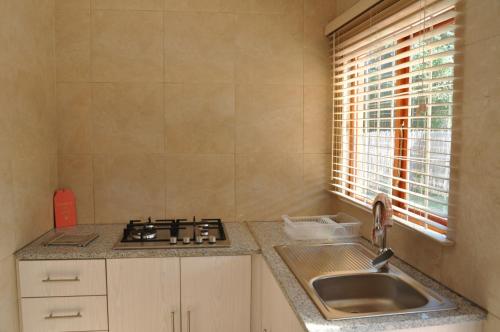 una cucina con lavandino, piano cottura e finestra di Kosi Khaya a Manguzi
