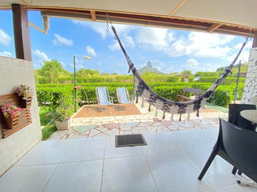 une terrasse couverte avec un hamac et un patio dans l'établissement FLAT BAÍA DO SANCHO, à Fernando de Noronha